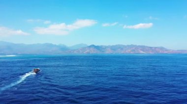 Mavi denizde yüzen sürat teknesi dağlara çıkıyor. Endonezya, Bali 'ye tropikal yolculuk.