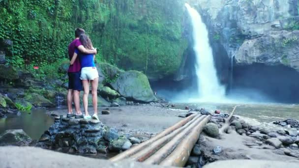 滝の近くに屋外に立つロマンチックなカップルのビデオ — ストック動画