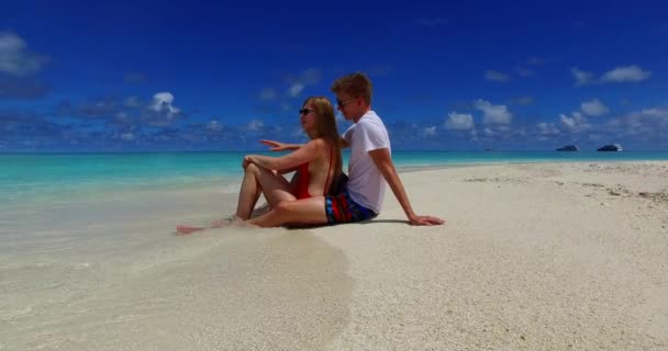 坐在热带海滩上的一对快乐的夫妇 — 图库视频影像