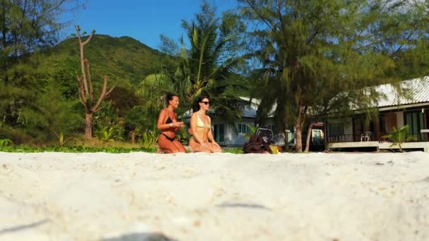 Twee Jonge Vriendinnen Zitten Aan Zandige Zeekust Zonnebaden Een Meisje — Stockvideo