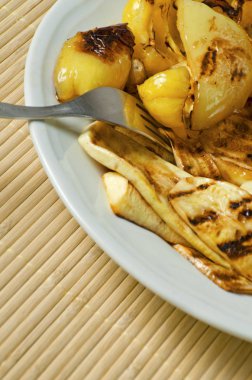 Kızarmış kabak ve çatal ile beyaz tabakta biber