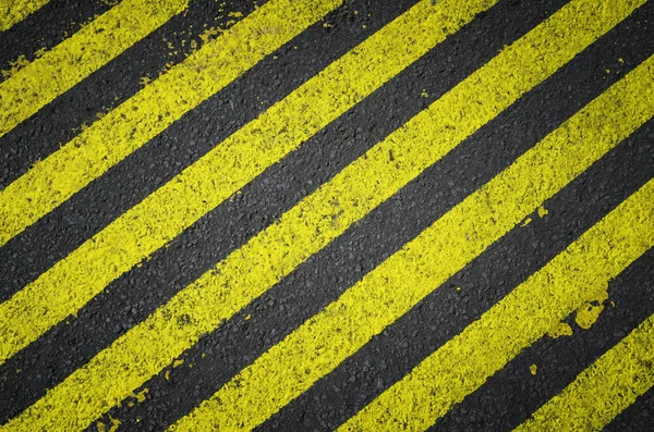 黒いアスファルトの道路に黄色のストライプの道路標示。建築面積の下. — ストック写真