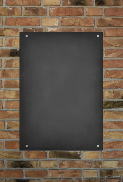 Blank blackboard at a brick wall background with space for text