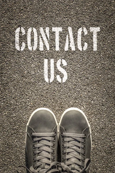 Contact Us stencil print on the asphalt road — Stock Photo, Image