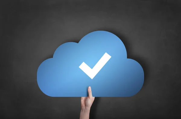 Biznesmen trzyma ikonę znacznika wyboru niebieski chmura na tablicy — Zdjęcie stockowe