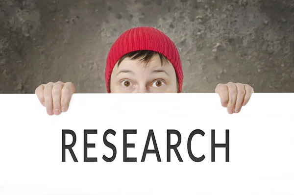 Überraschte Frau mit roter Mütze mit Forschungsausweis. — Stockfoto