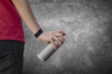 Karanlık bir konsantrasyon önünde tutan bir grafiti sprey bulanık el olabilir