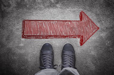 Kırmızı ok ile asfalt yolda spor ayakkabı