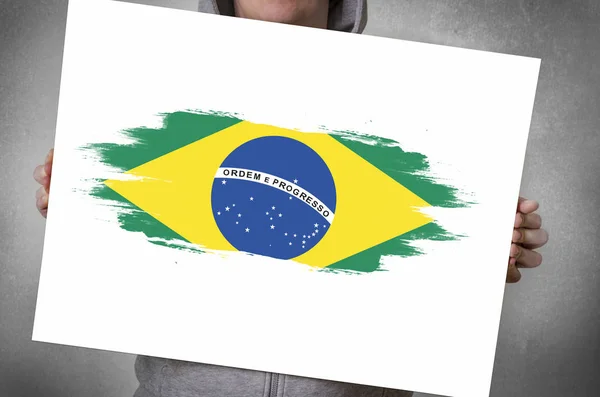 Człowiek posiadający biały sztandar z flaga Brazylii — Zdjęcie stockowe