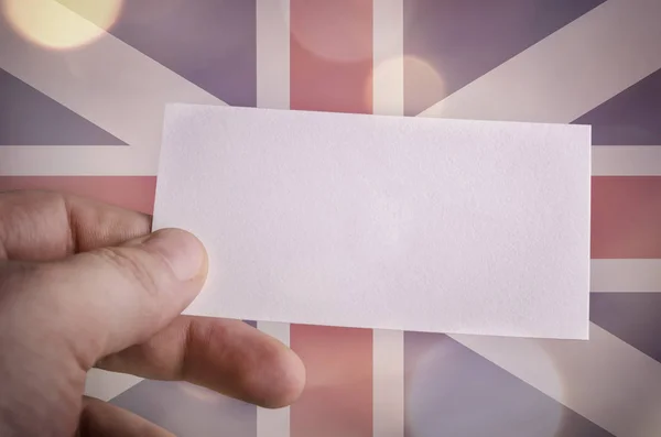 Hand met een blanco visitekaartje met de Britse vlag — Stockfoto