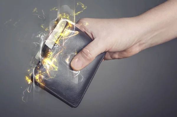 Αρσενική χέρι κρατά ένα κάψιμο πορτοφόλι. Εικονογράφηση φωτιά. — Φωτογραφία Αρχείου