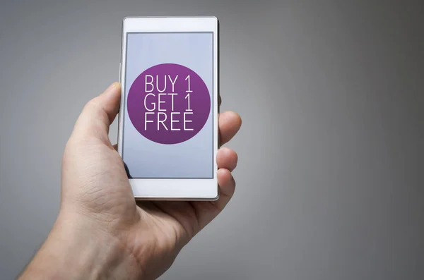 Vesz egy kap egy szabad ikon okos telefon a kezében a szürke háttér — Stock Fotó