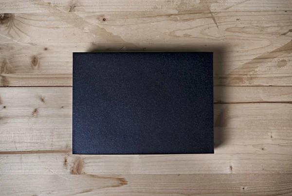 Paper black box mock up on wooden background