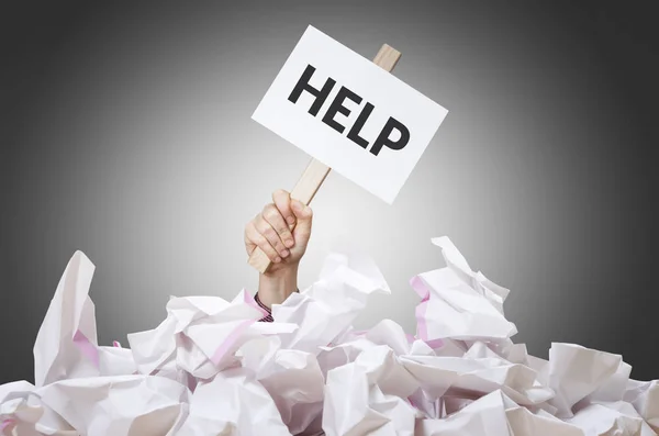 Help placard in hand with crumpled paper pile. — Stock Photo, Image