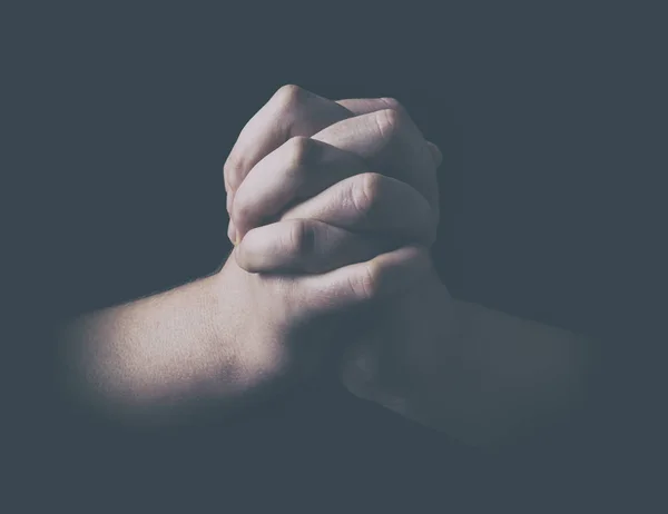 Mãos de homem em posição de oração imagem de tecla baixa — Fotografia de Stock
