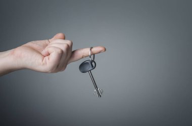 Evin anahtarı koyu arka plan üzerinde veren el