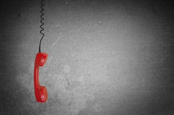 Красный телефонный приемник на сером фоне с копировальным пространством — стоковое фото