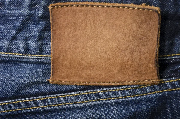 Étiquette de jeans en cuir blanc cousue sur un jean bleu — Photo