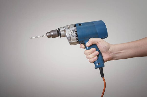 A man's hand with an electric power drill. Mechanic Service Maintenance Concept