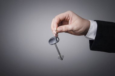 Bir anahtar tutan işadamı el. Sağ kapı seçin.