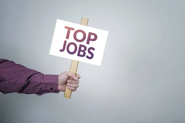 Affisch i handen, affärsidé med text Top Jobs. — Stockfoto