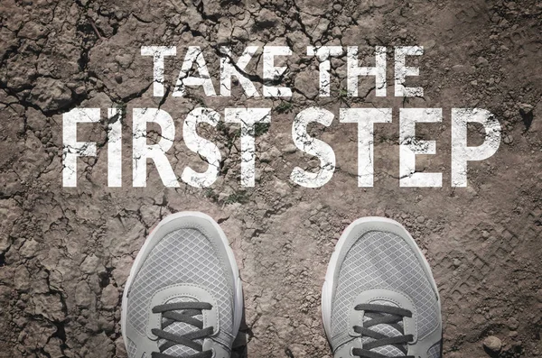 Ta första steget text och sneakers på torra land ovanifrån — Stockfoto