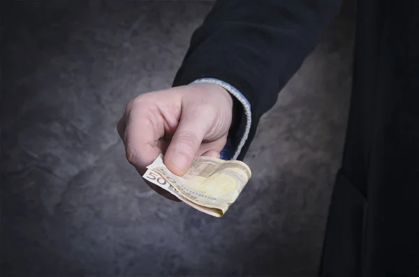Geschäftsmann gibt Geld, 50-Euro-Schein, auf grauem Hintergrund - Finanzkonzept — Stockfoto