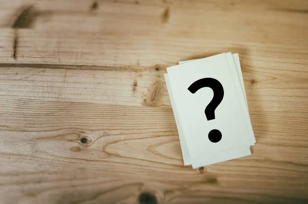 Question mark on wooden desk background. Concept for confusion, question or solution. — Stock Photo, Image