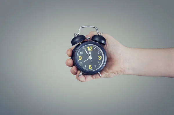 Hora de tomar decisiones. Reloj despertador en mano mostrando de cinco a doce . — Foto de Stock