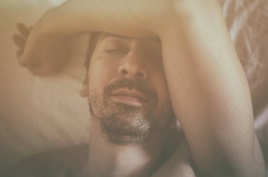 Depresif adam onun yatakta yatan ve kendini kötü hissediyor. Yumuşak odak.