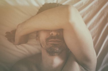 Depresif adam onun yatakta yatan ve kendini kötü hissediyor. Yumuşak odak.