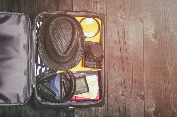 Offene Reisetasche auf Holzboden-Hintergrund, Draufsicht. — Stockfoto