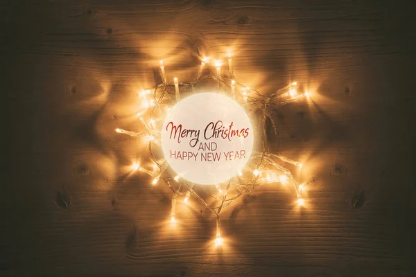Luzes de Natal com bola brilhante no fundo da mesa de madeira — Fotografia de Stock