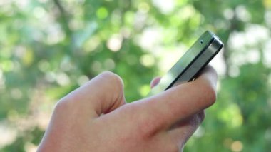 Akıllı telefonda yazan erkek eller.