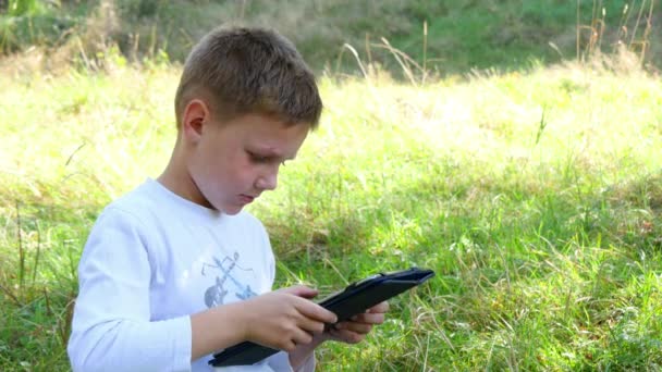 Szczęśliwy młody chłopak za pomocą tabletu — Wideo stockowe
