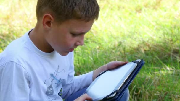 Niño joven feliz usando tableta — Vídeo de stock