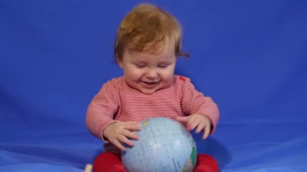 Маленький мальчик играет с глобусом — стоковое видео
