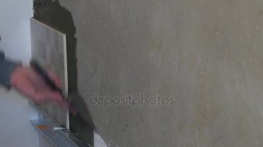 Duvardaki seramik yapıştırıcı koyarak