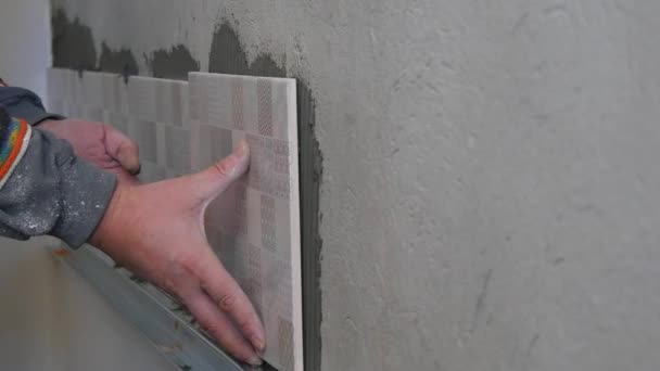 Uomo Applicazione di piastrelle di ceramica a una parete della cucina — Video Stock