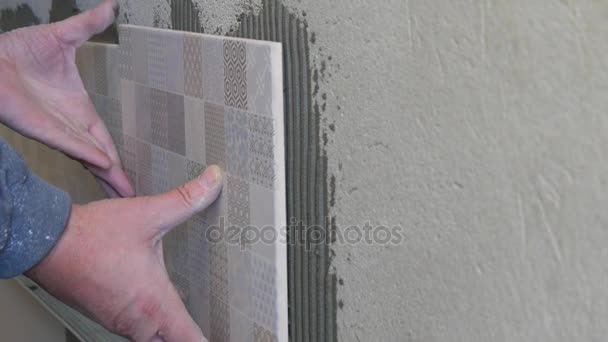 Man tillämpar keramiska plattor till en köksväggen — Stockvideo