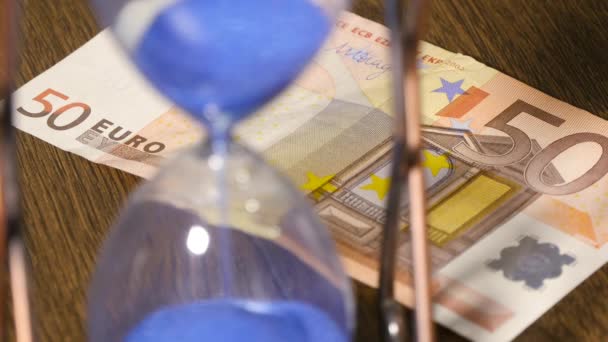 Песочные часы с банкнотой евро — стоковое видео