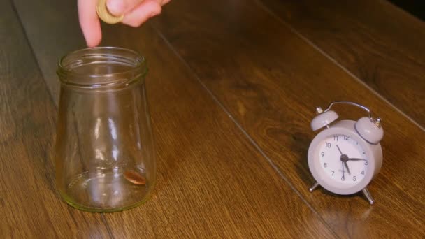 Hand zetten munten In glazen pot — Stockvideo