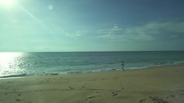 Dziewczyna pracuje na piaszczystej plaży, w pobliżu morza — Wideo stockowe