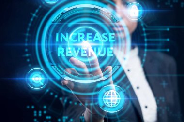 İş, Teknoloji, İnternet ve ağ konsepti. Genç işadamı geleceğin sanal ekranı üzerinde çalışıyor ve yazıyı görüyor: gelirin artırılması. 