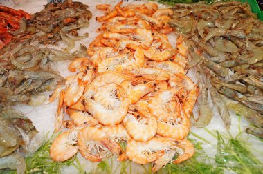 Taze karidesler soğuk buzun üzerinde yatar. Karides satışı. Taze deniz ürünleri buzda izole edilir. Beyaz buzda izole edilmiş kırmızı karidesler.