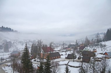 Kış dağ köyü Ukrayna Karpatlar saran. Ukrayna Karpatlar karlı dağ vadisinde küçük evlerde. Kış aylarında Ukrayna Karpatlar.