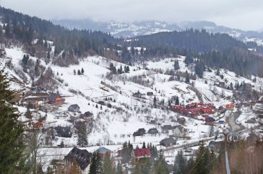 Kış dağ köyü Ukrayna Karpatlar saran. Ukrayna Karpatlar karlı dağ vadisinde küçük evlerde. Kış aylarında Ukrayna Karpatlar.