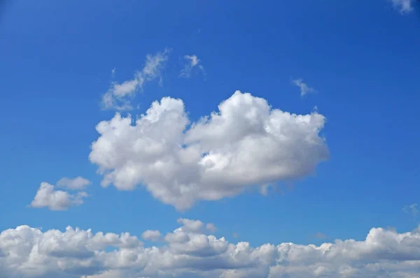 Cloud in the form of heart. Fluffy white clouds against a blue sky on a sunny summer day.