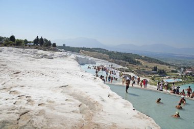 İnsanlar banyo ve sıcak, sıcak bir günde Pamukale kaplıca içinde bekletin. Türkiye'de Pamukale kireçtaşı havzaları.                               