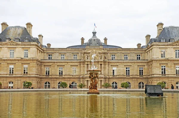    Lüksemburg Sarayı güzel bir bahçesi yeşilliklerle çevrilidir. Lüksemburg Bahçeleri. Çeşme ve gölet Lüksemburg Sarayı önünde yeşil su ile.                            